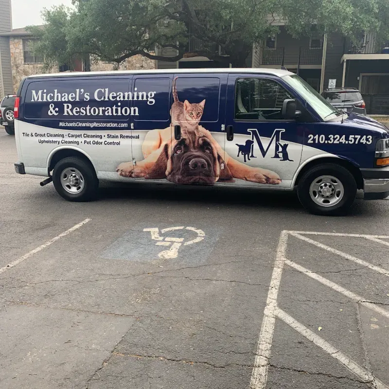 A michael 's cleaning and restoration van is parked in a handicapped parking spot