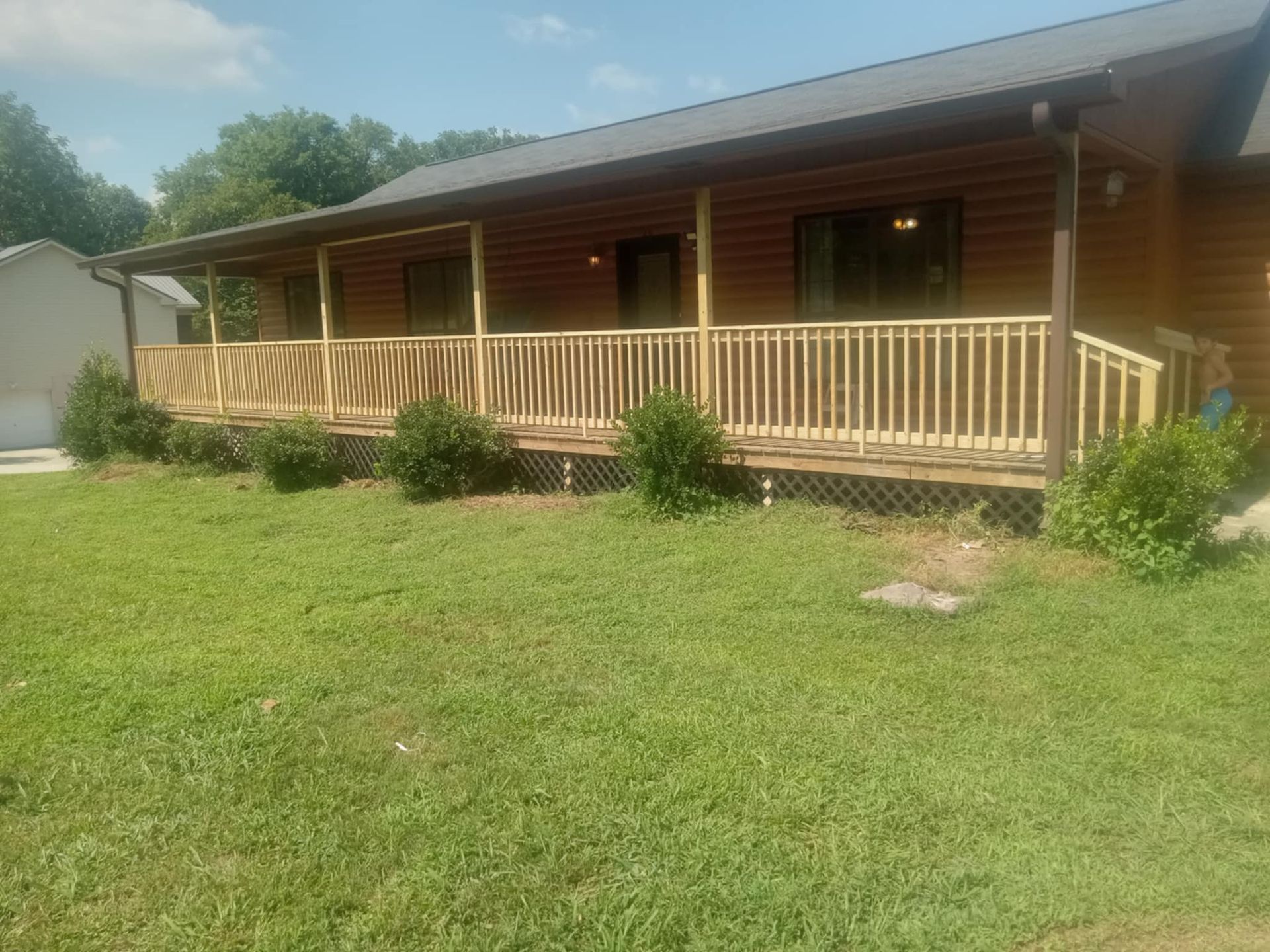 A log cabin with a large porch and a metal roof.