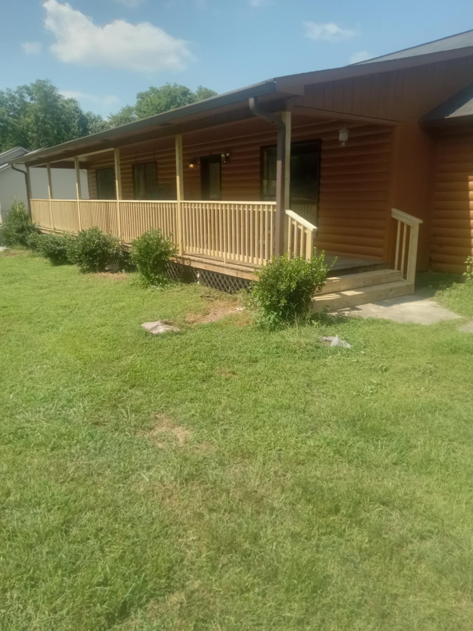 A log cabin with a large porch and stairs