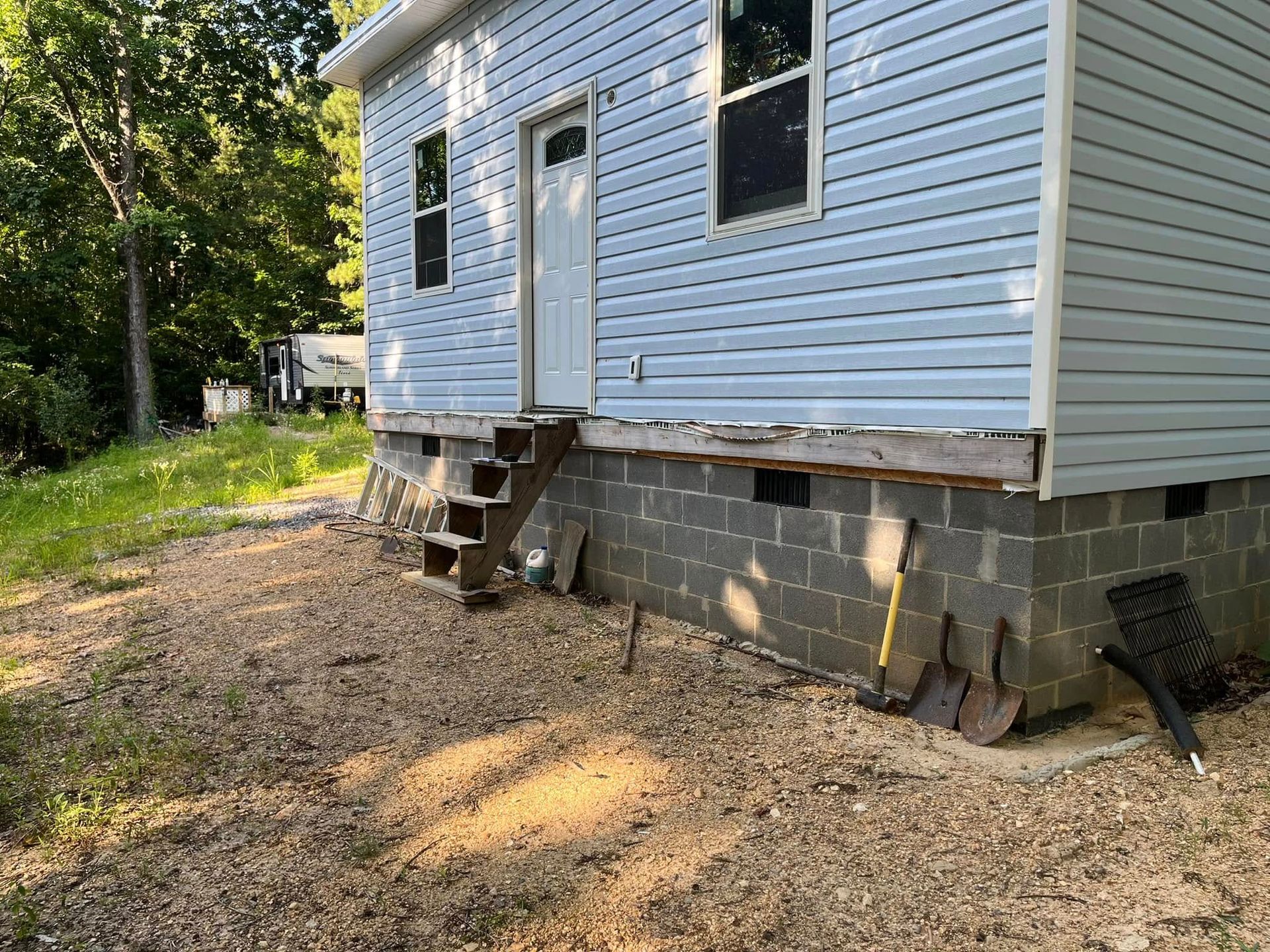 A small house is sitting on top of a brick foundation.