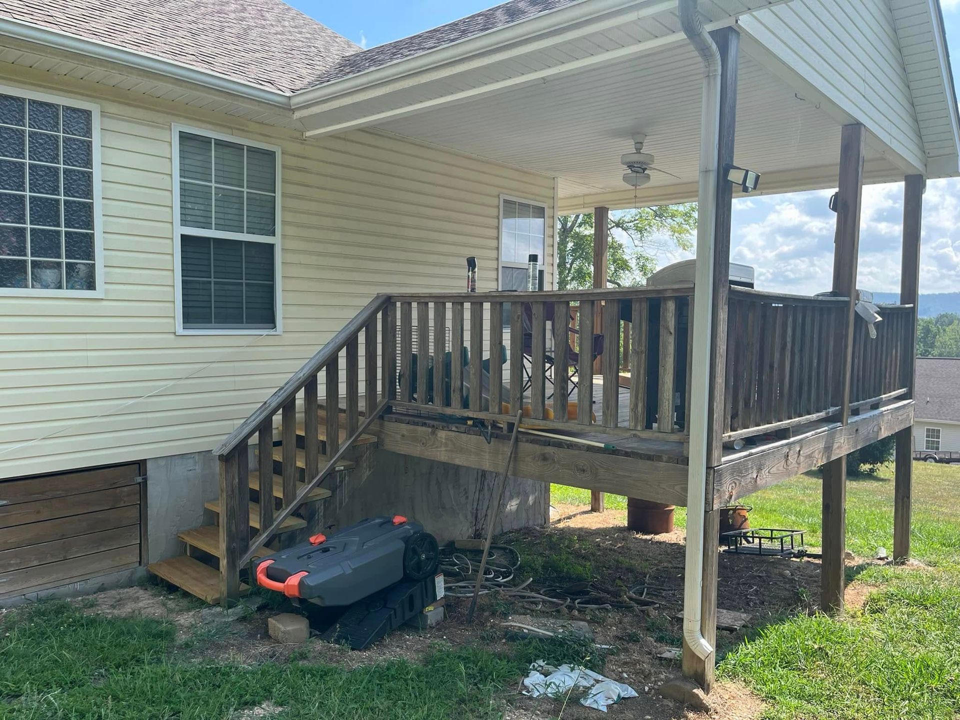 A house with a porch and stairs on the side of it.