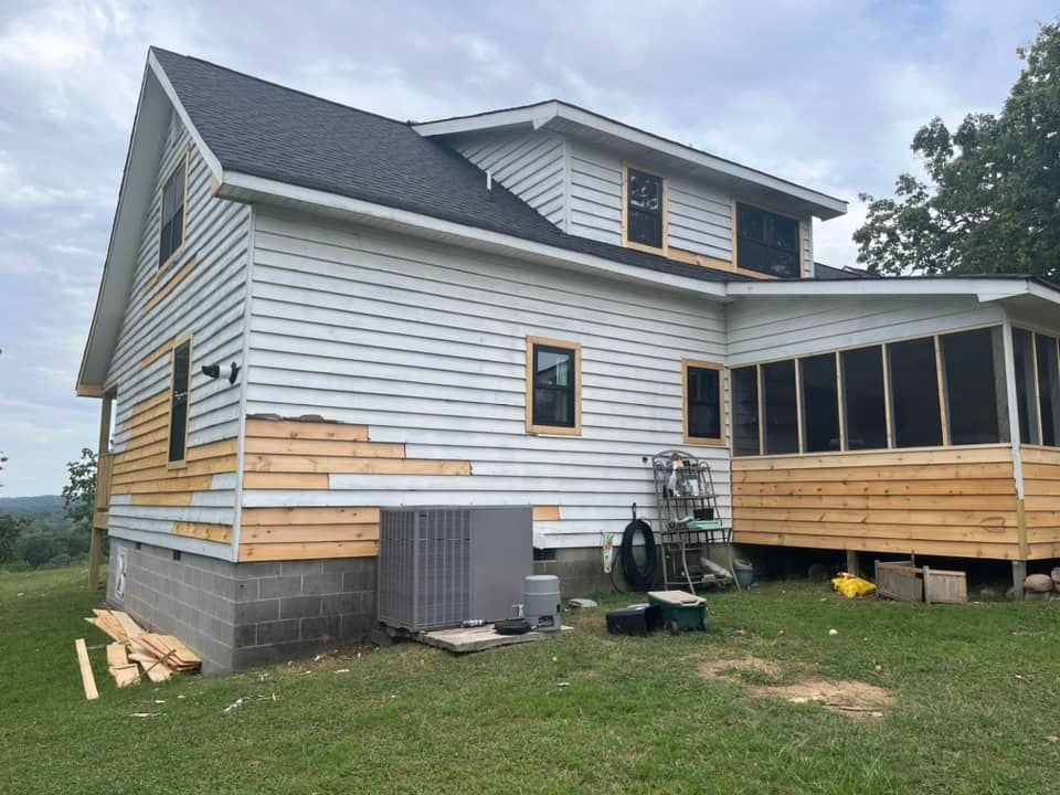 A white house with a screened in porch is being remodeled.