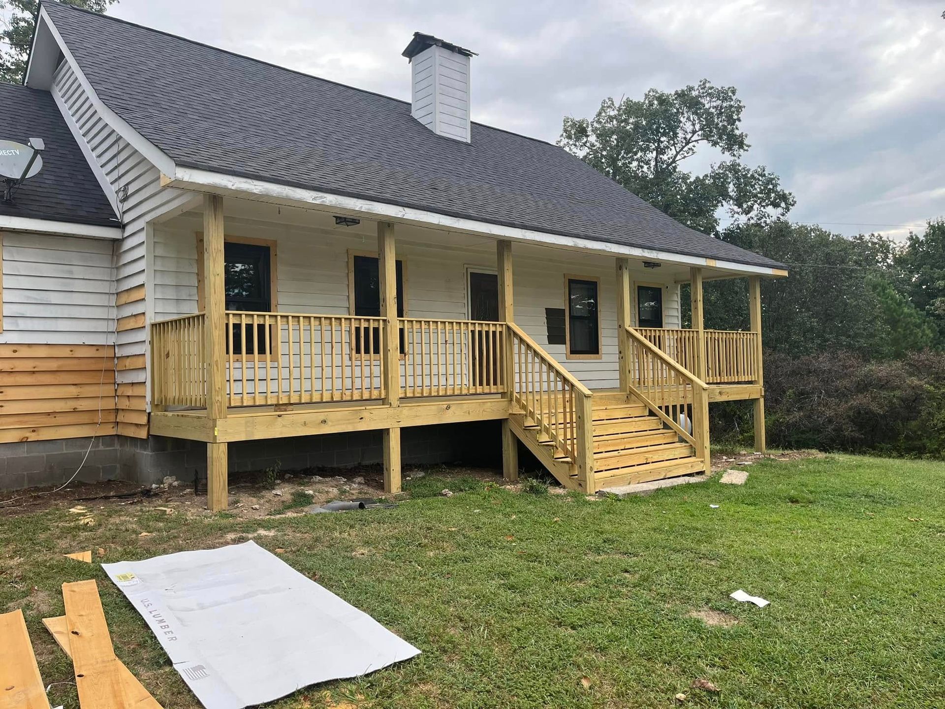 A house with a large porch and stairs is being built.