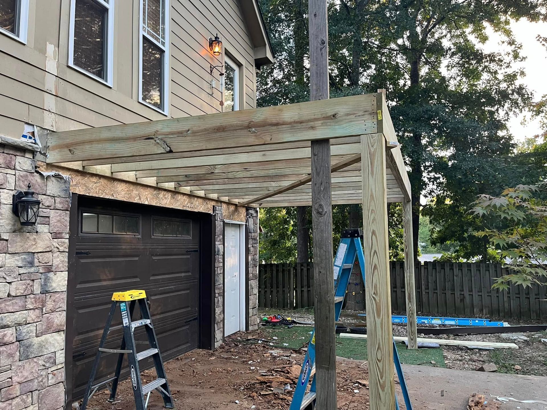 A wooden pergola is being built over a garage door.
