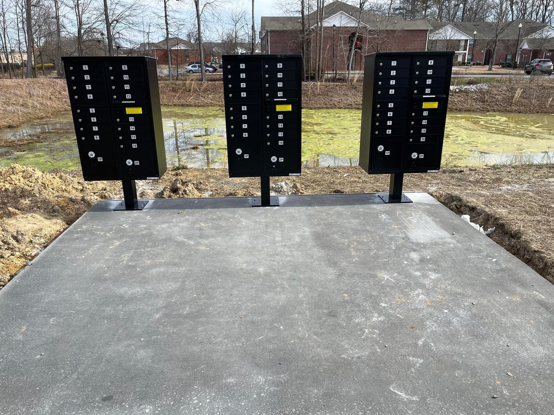 Three mailboxes are lined up on a concrete platform