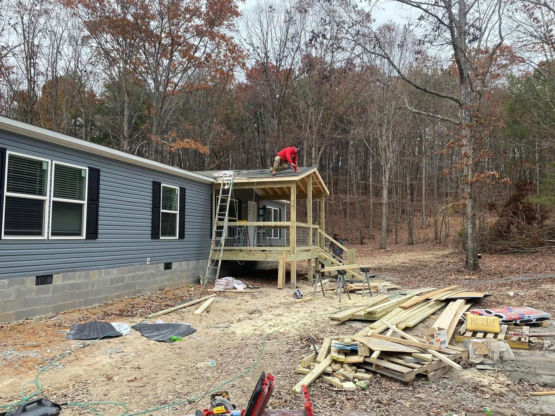 A man is working on the roof of a mobile home.
