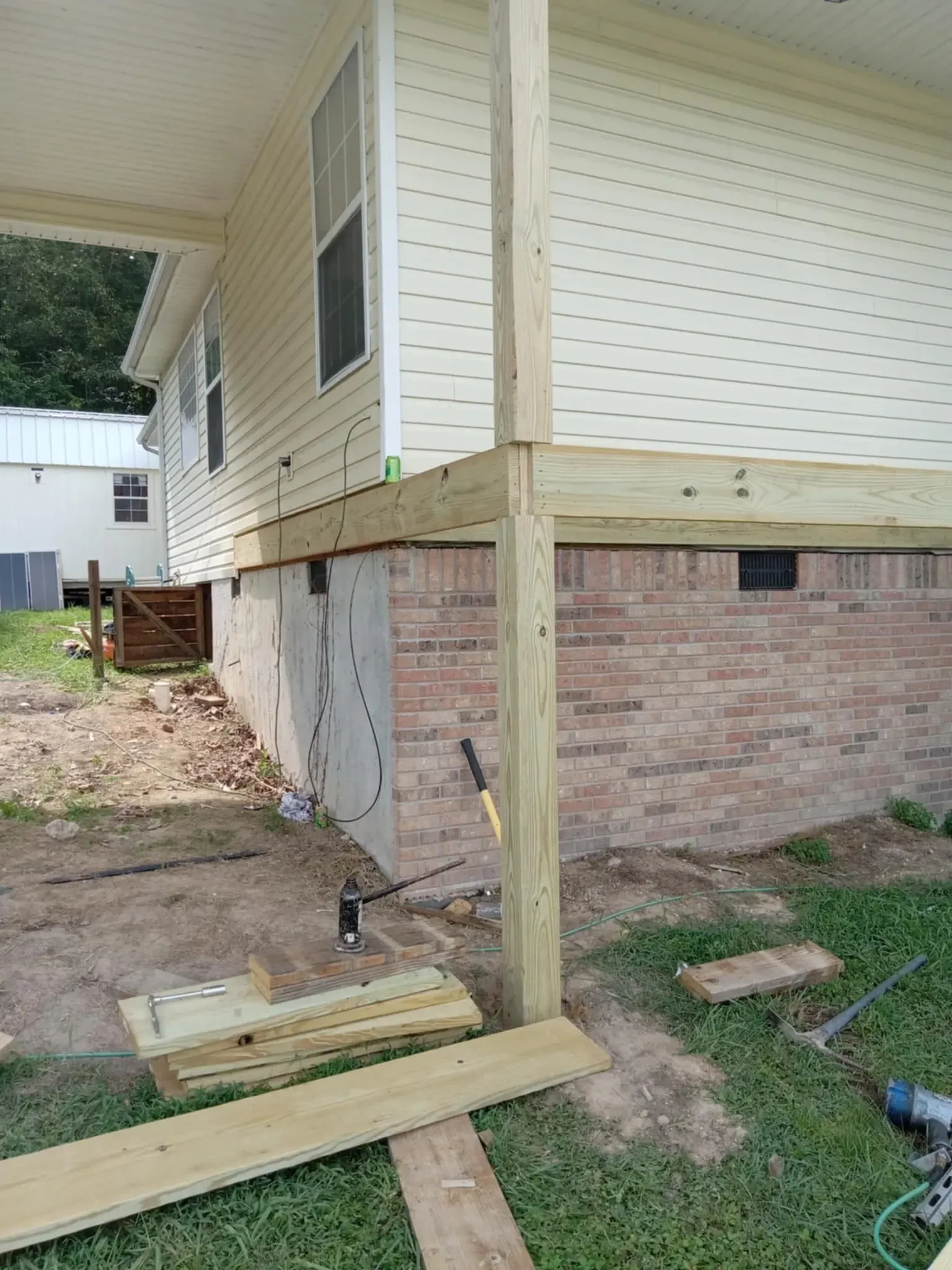 A wooden deck is being built on the side of a house.