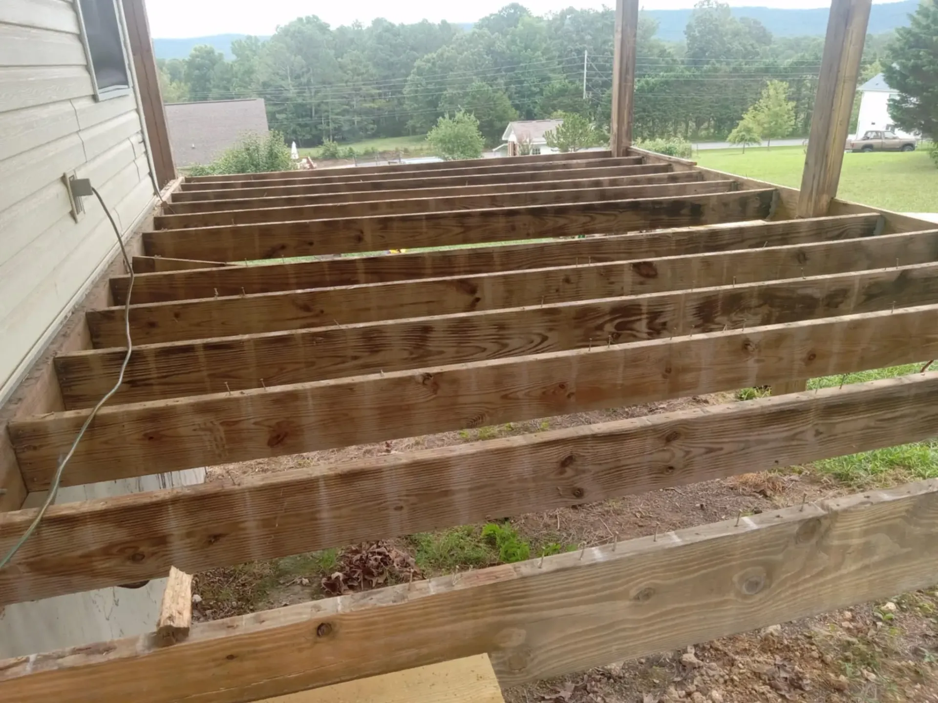 A wooden deck is being built on the side of a house.