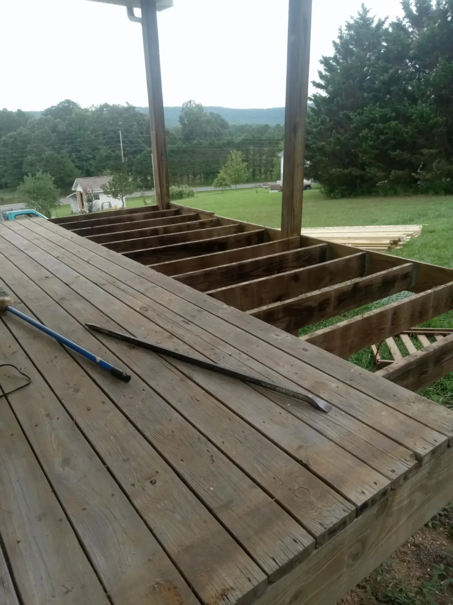 A wooden deck is being built with a rake on top of it.