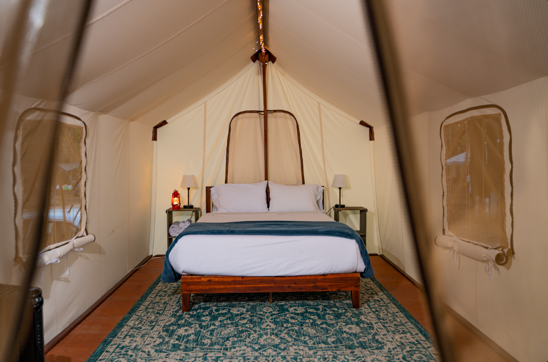 There is a bed in the middle of a tent.