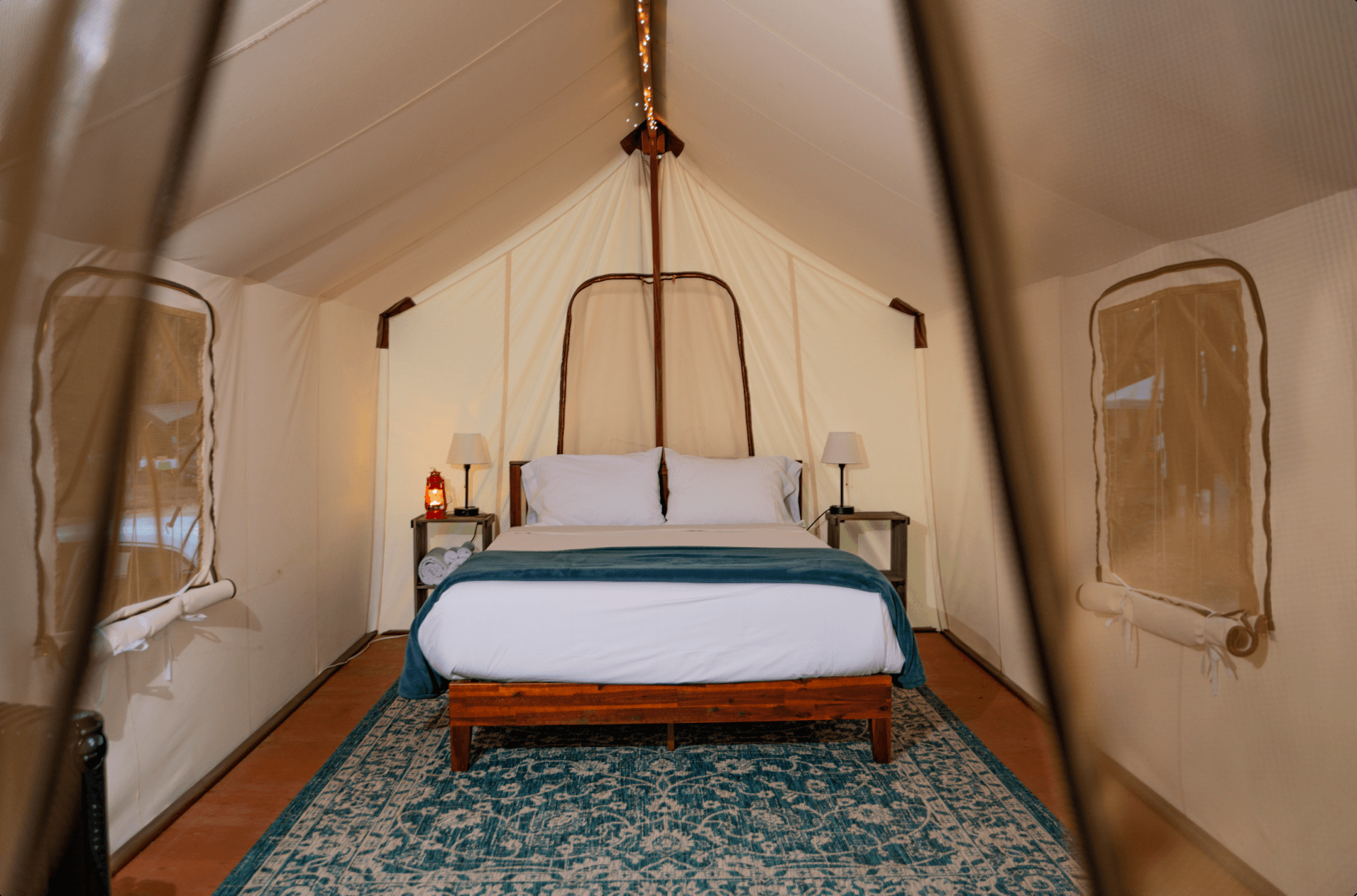 There is a bed in the middle of a tent.