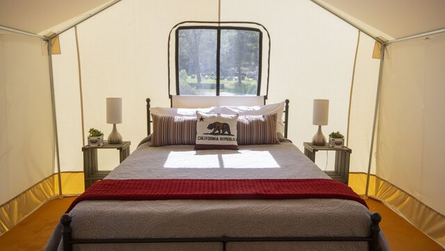 queen bed inside premium canvas glamping tent