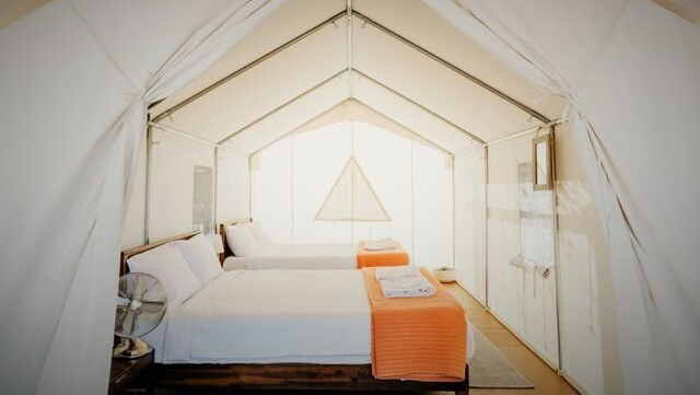 two queen beds inside canvas glamping tent