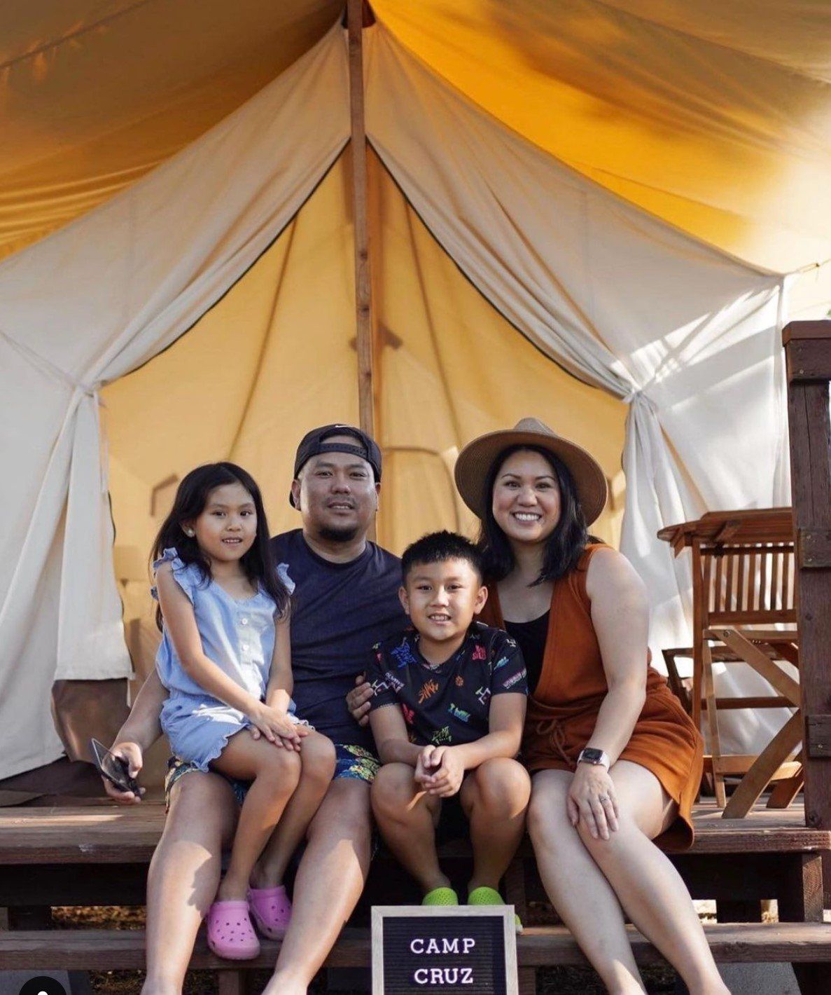 A family is posing for a picture in front of a tent.