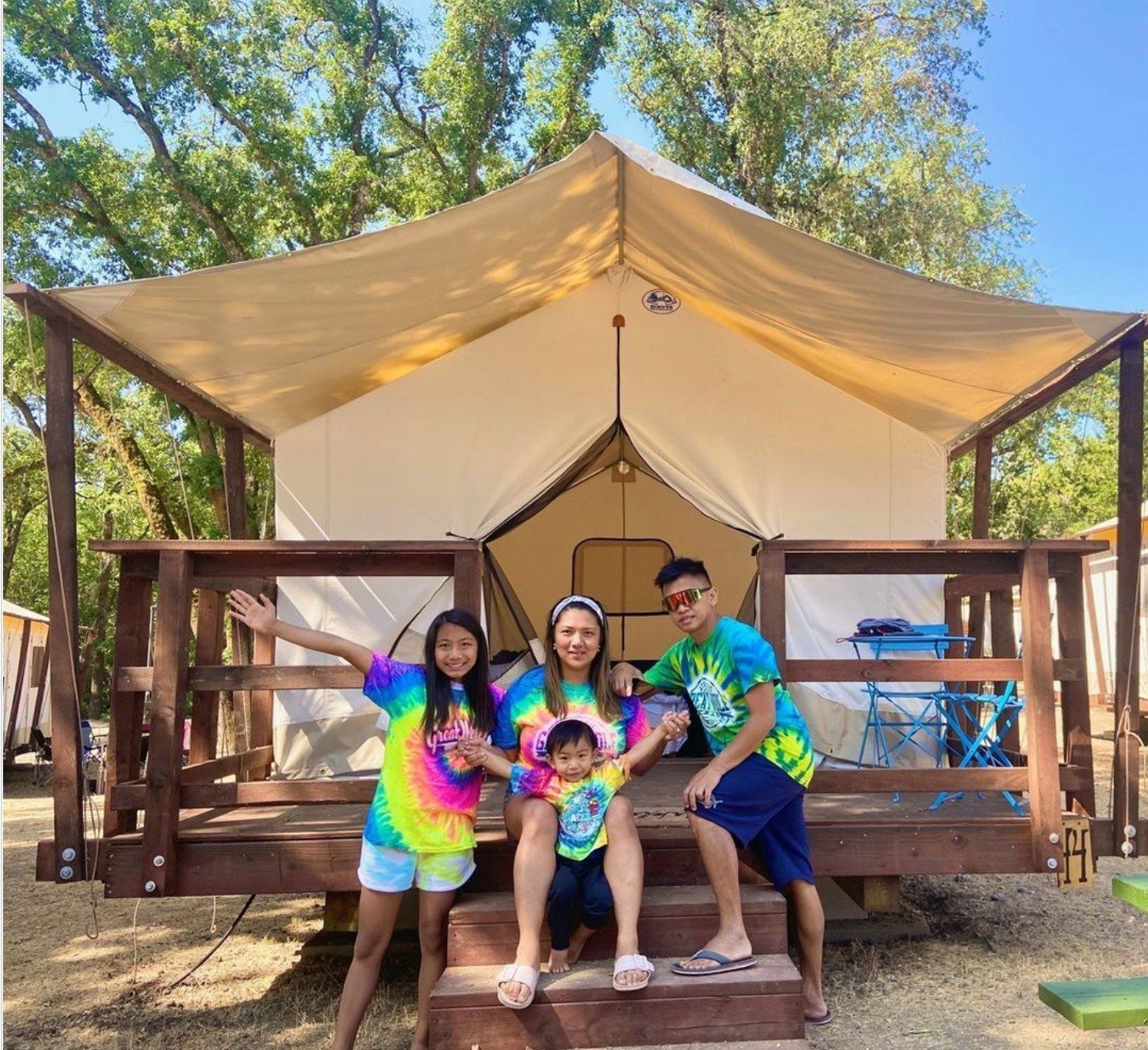 A family posing for a picture in front of a tent