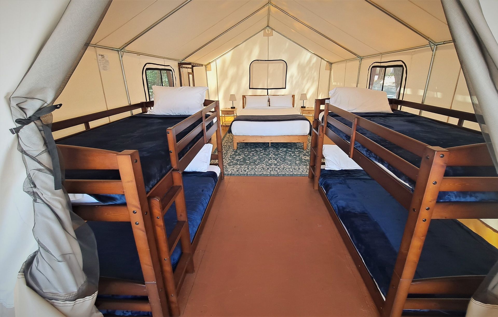The inside of a tent with bunk beds in it