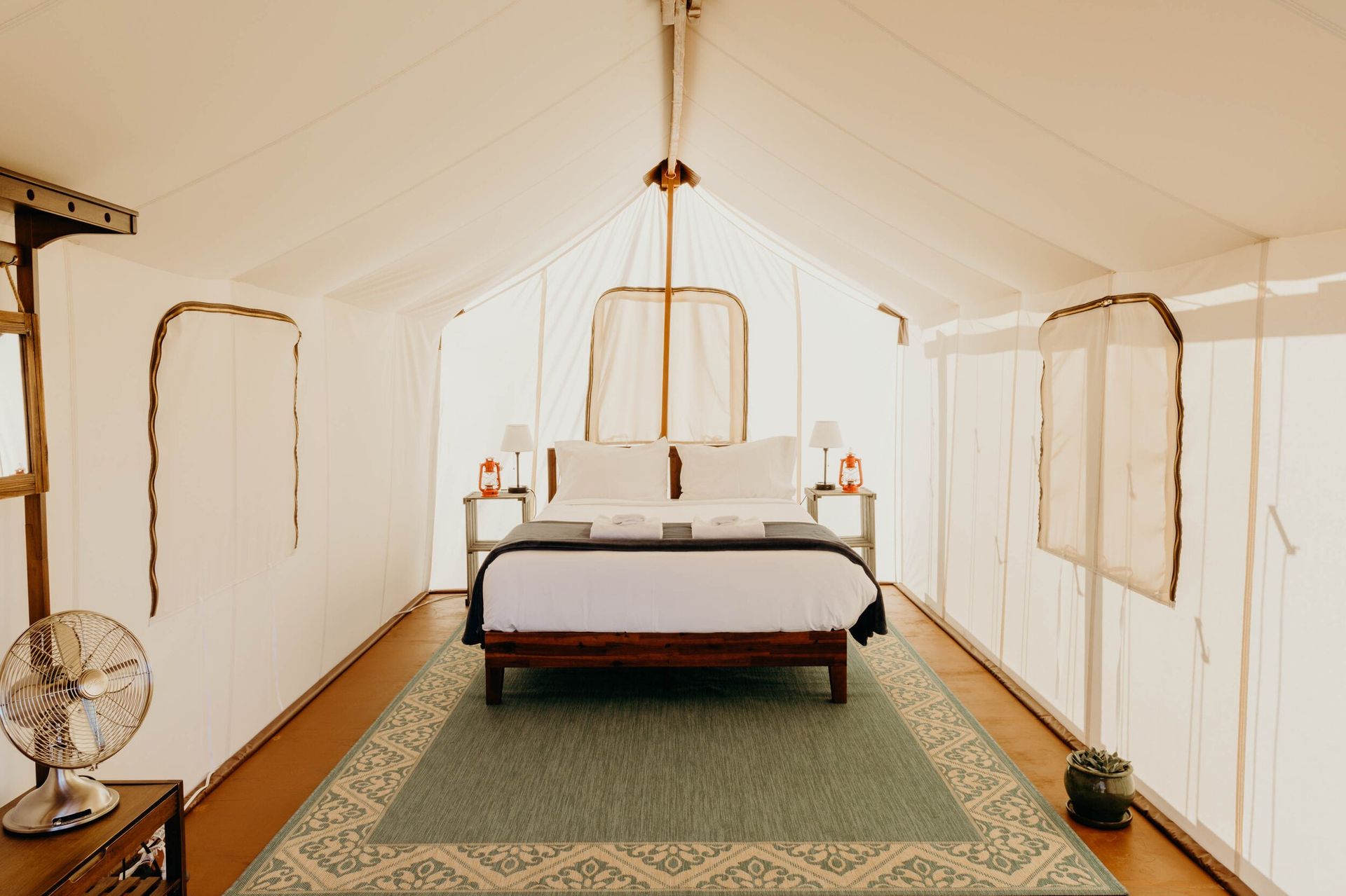 A bedroom in a tent with a bed and a rug.