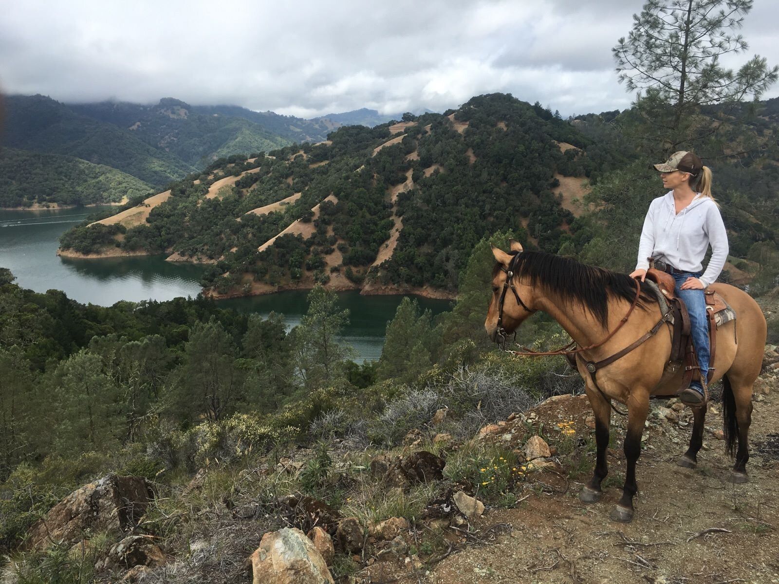 woman on horse overlooking lake and mountains