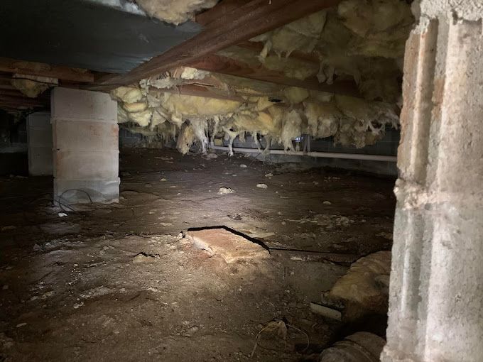 A basement with a lot of insulation hanging from the ceiling.