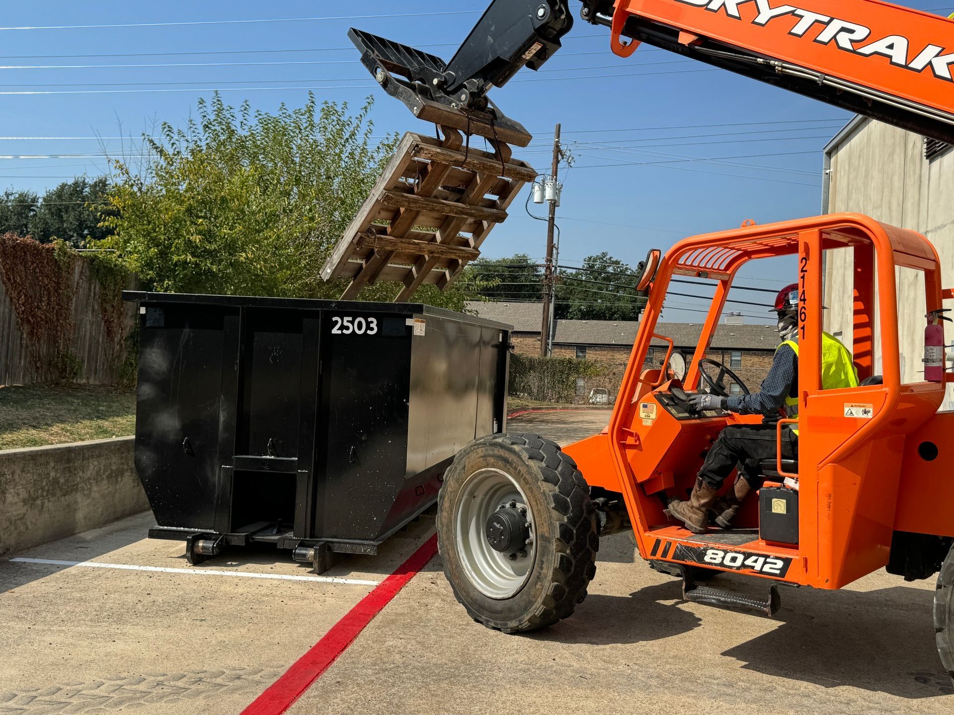 Three dumpsters are parked next to each other in a parking lot.