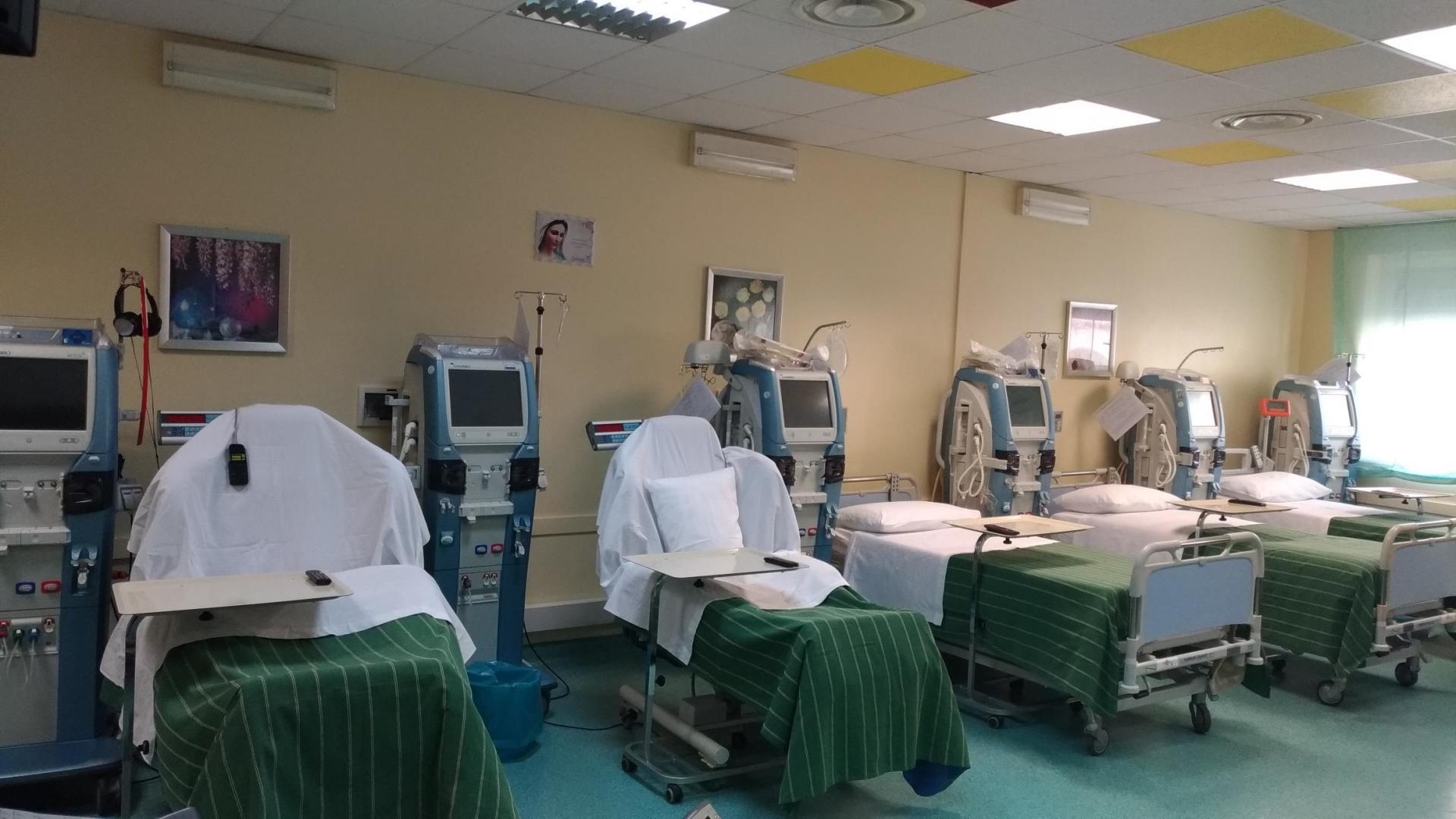 Una stanza d'ospedale con molti letti e monitor