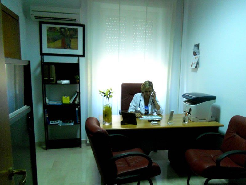 Una donna seduta a una scrivania che parla al cellulare