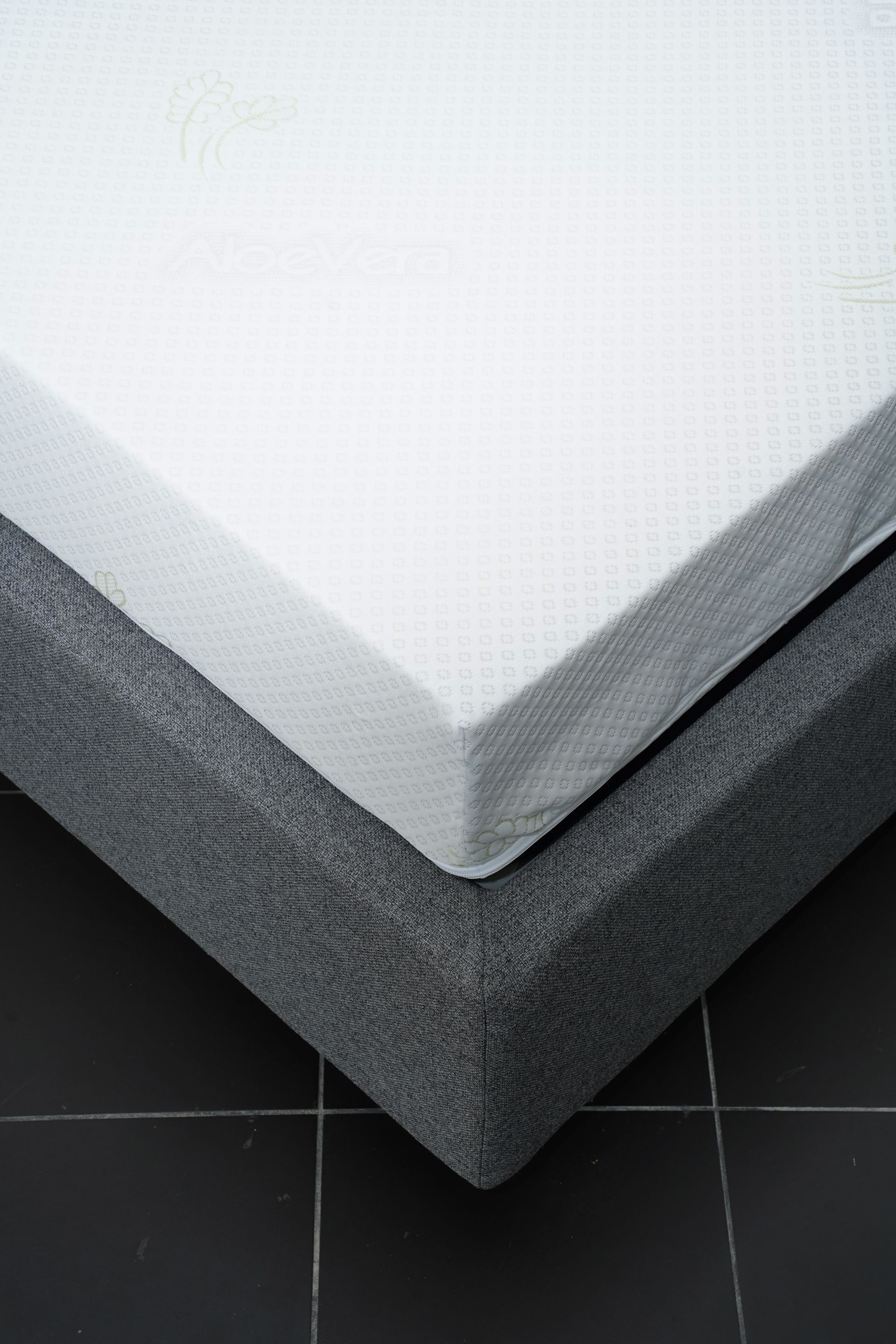 Un letto con un materasso e un coprimaterasso sopra