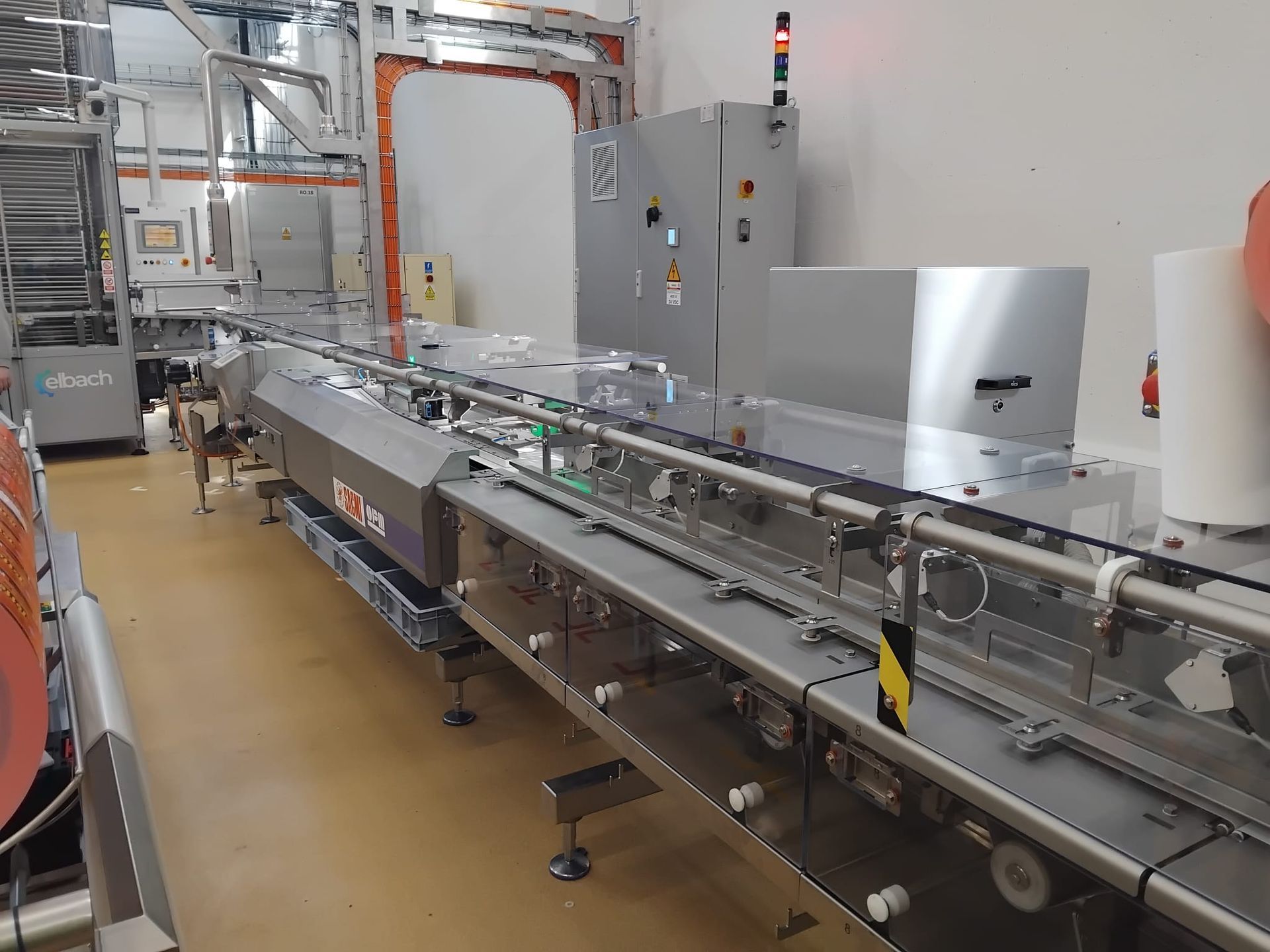 Long stainless steel conveyor line with modular belts for high-capacity food production – DM Technic.