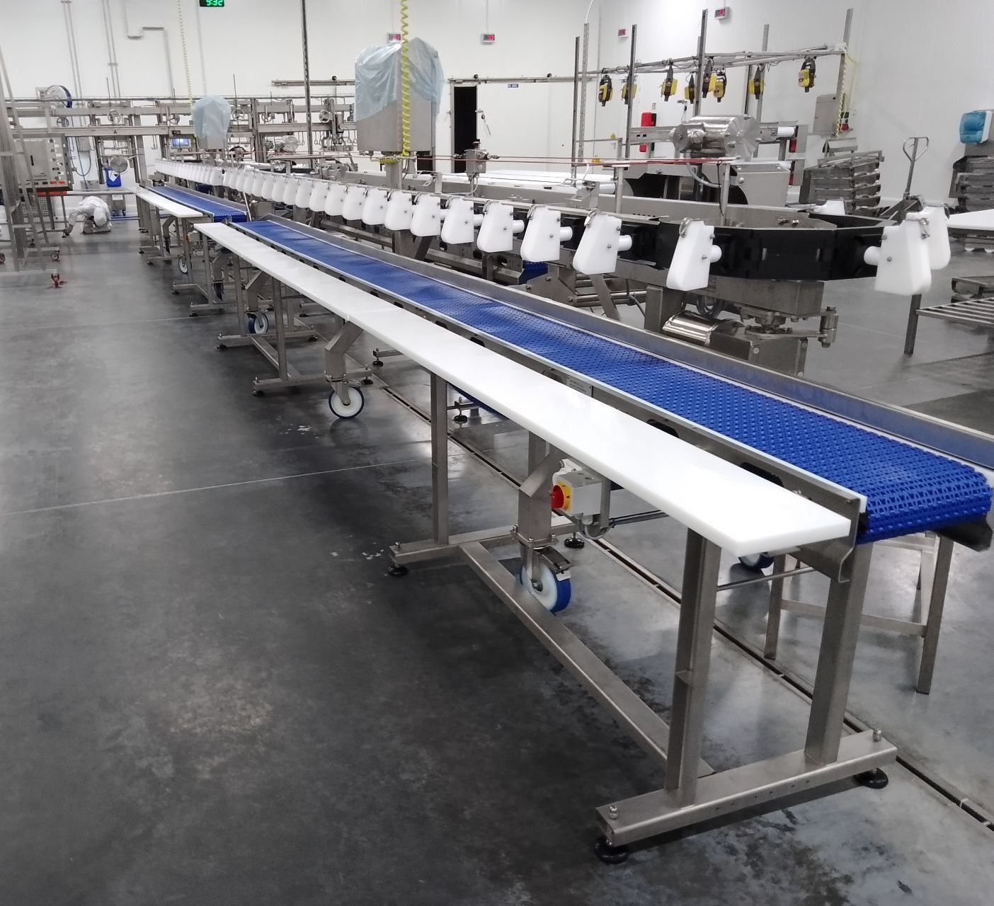 Long stainless steel conveyor line with modular belts for high-capacity food production – DM Technic.