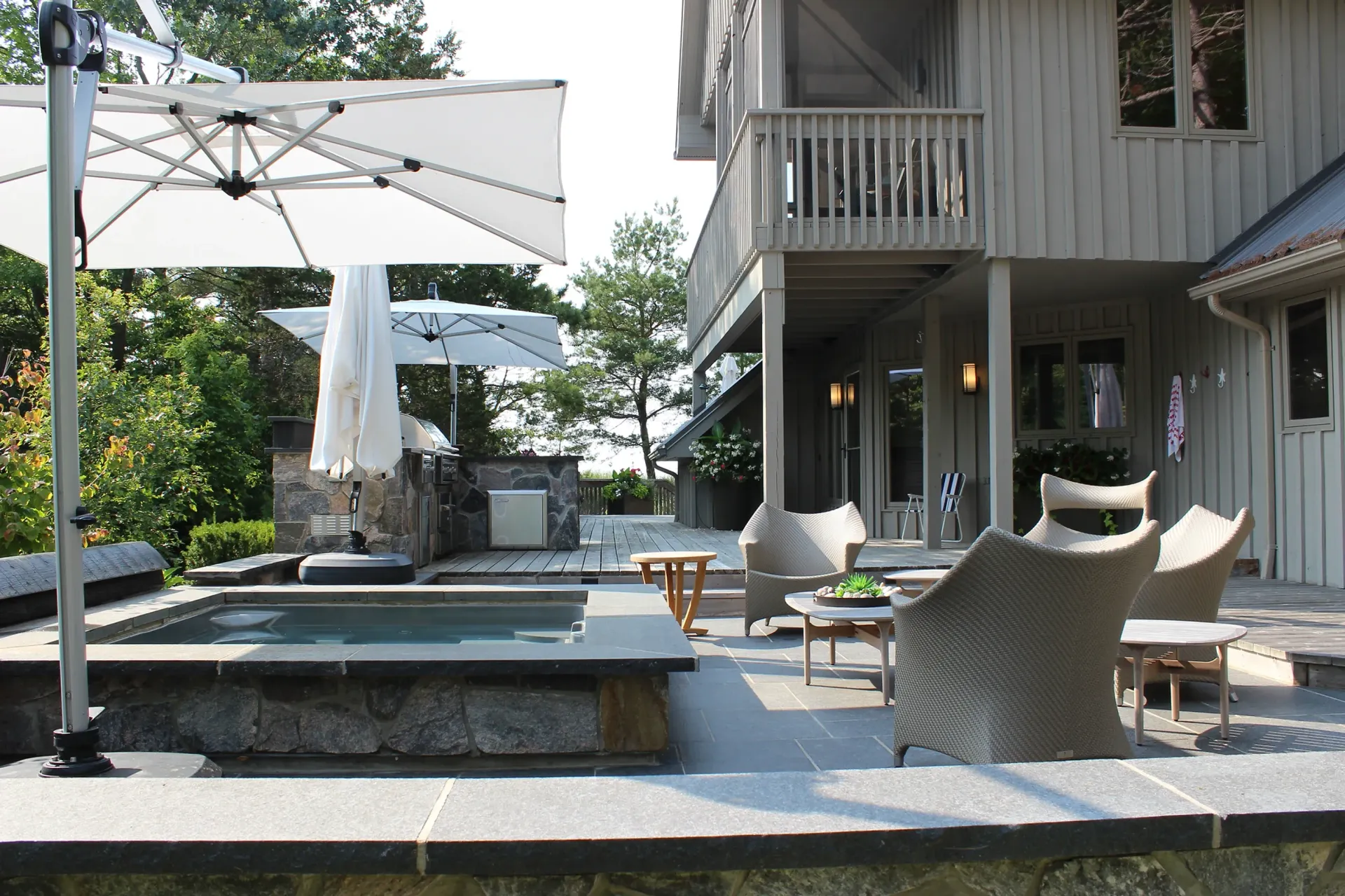 A large house with a pool and umbrellas in front of it