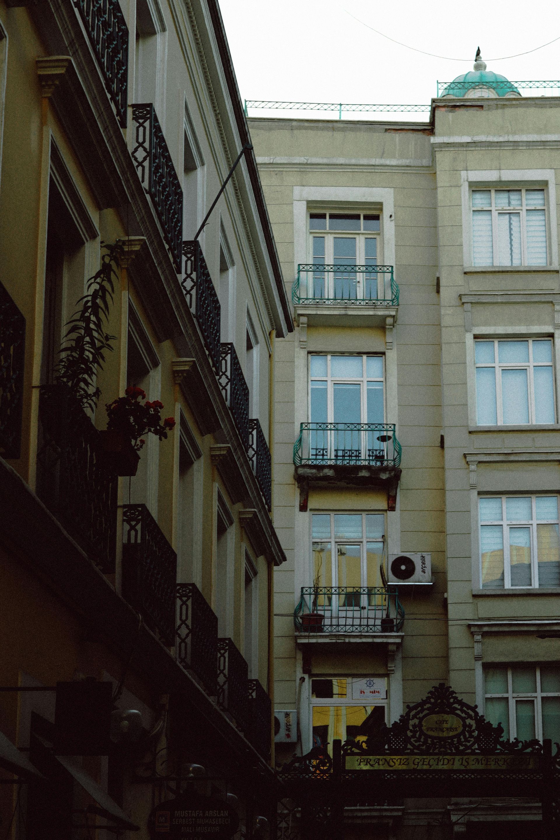 Un bâtiment avec beaucoup de fenêtres et de balcons est entouré d'autres bâtiments.