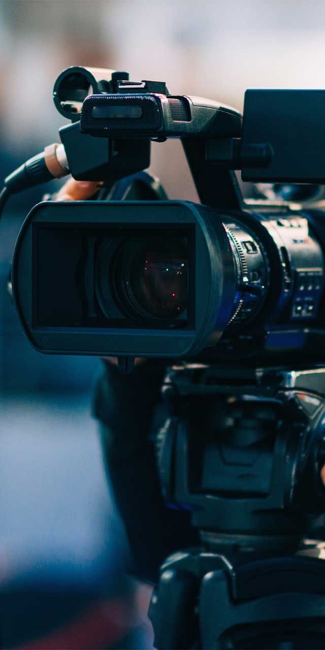 A close up of a video camera on a tripod.