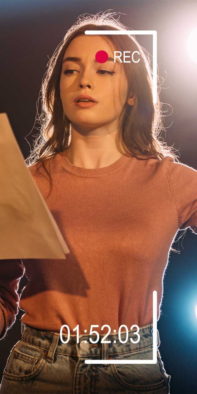 A woman is singing into a microphone on a stage.