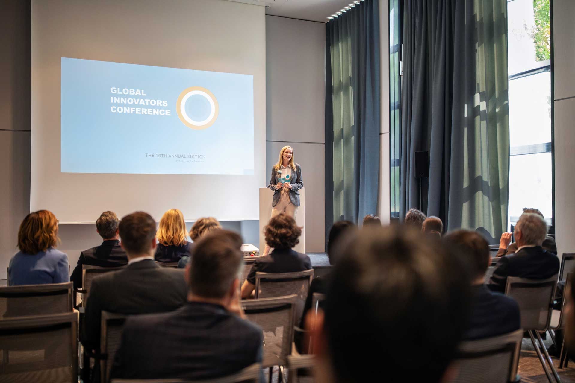 A woman is giving a presentation to a group of people in a conference room.