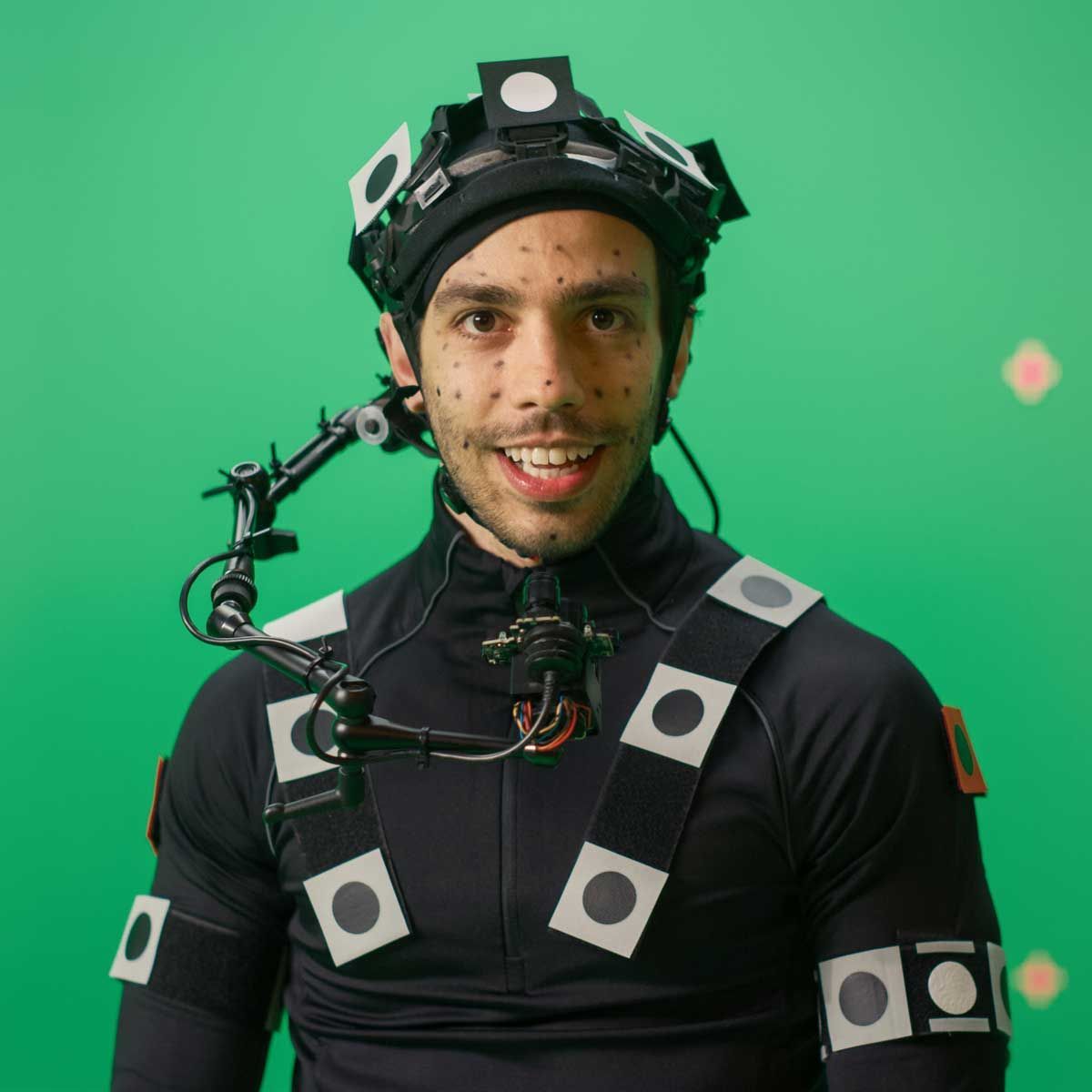 A man wearing a helmet and a costume with a green background