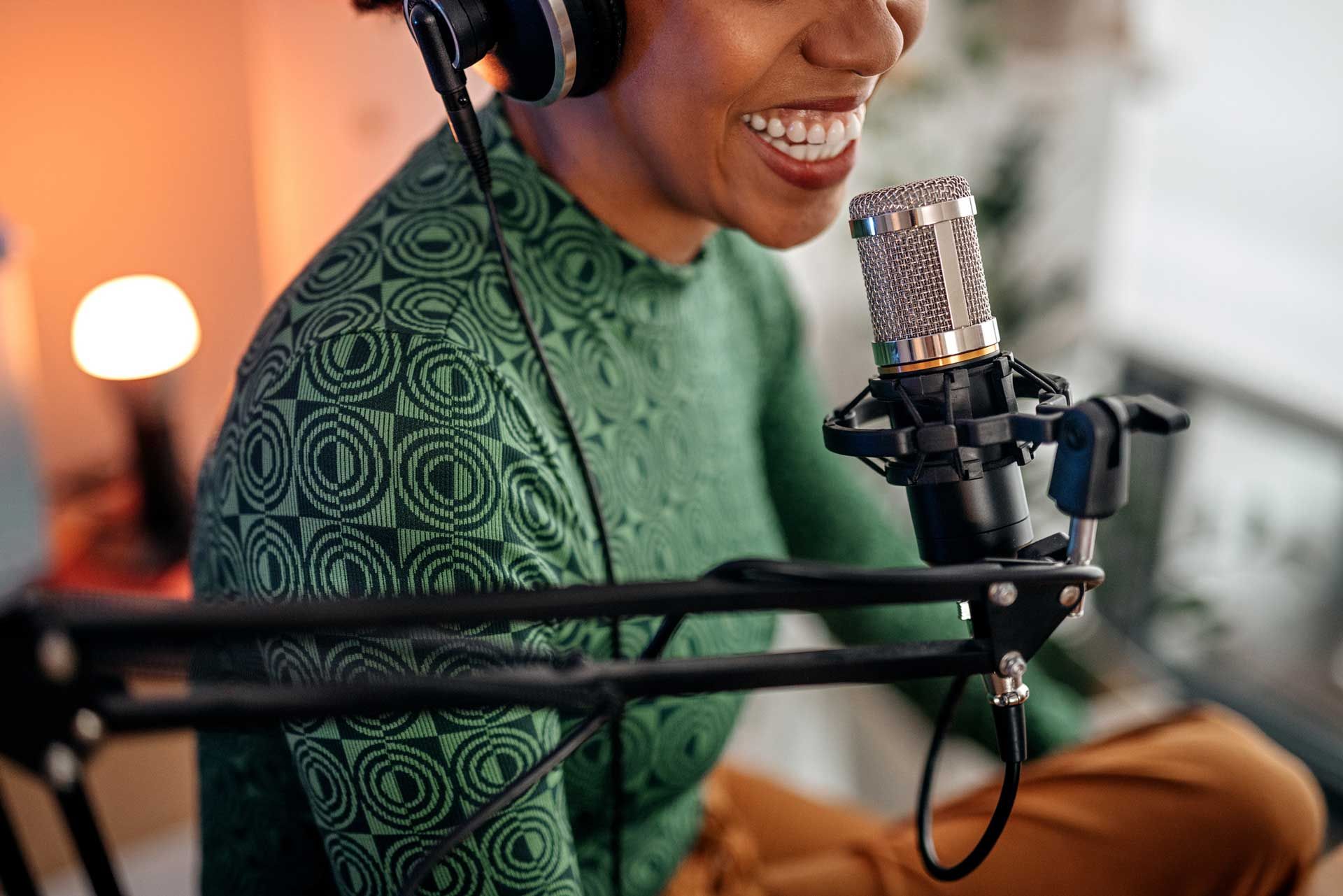 A woman is sitting in front of a microphone wearing headphones.