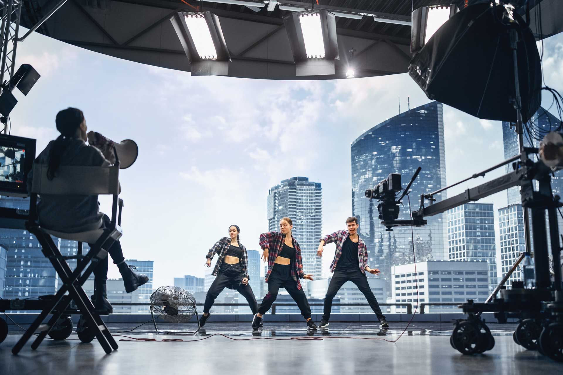 A group of young women are dancing in front of a camera in a studio.