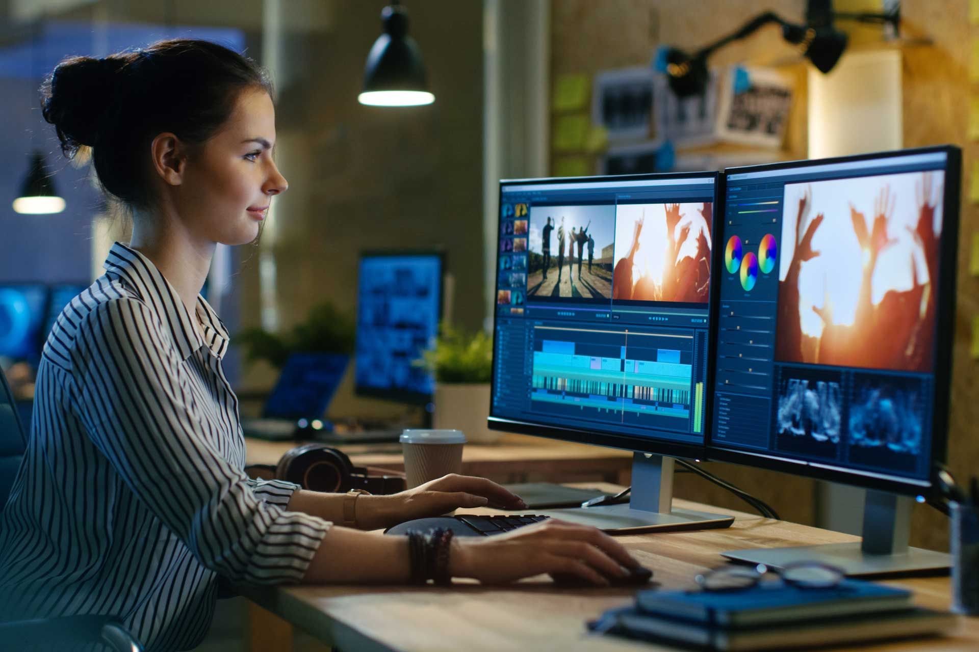 A woman is sitting at a desk working on a computer.