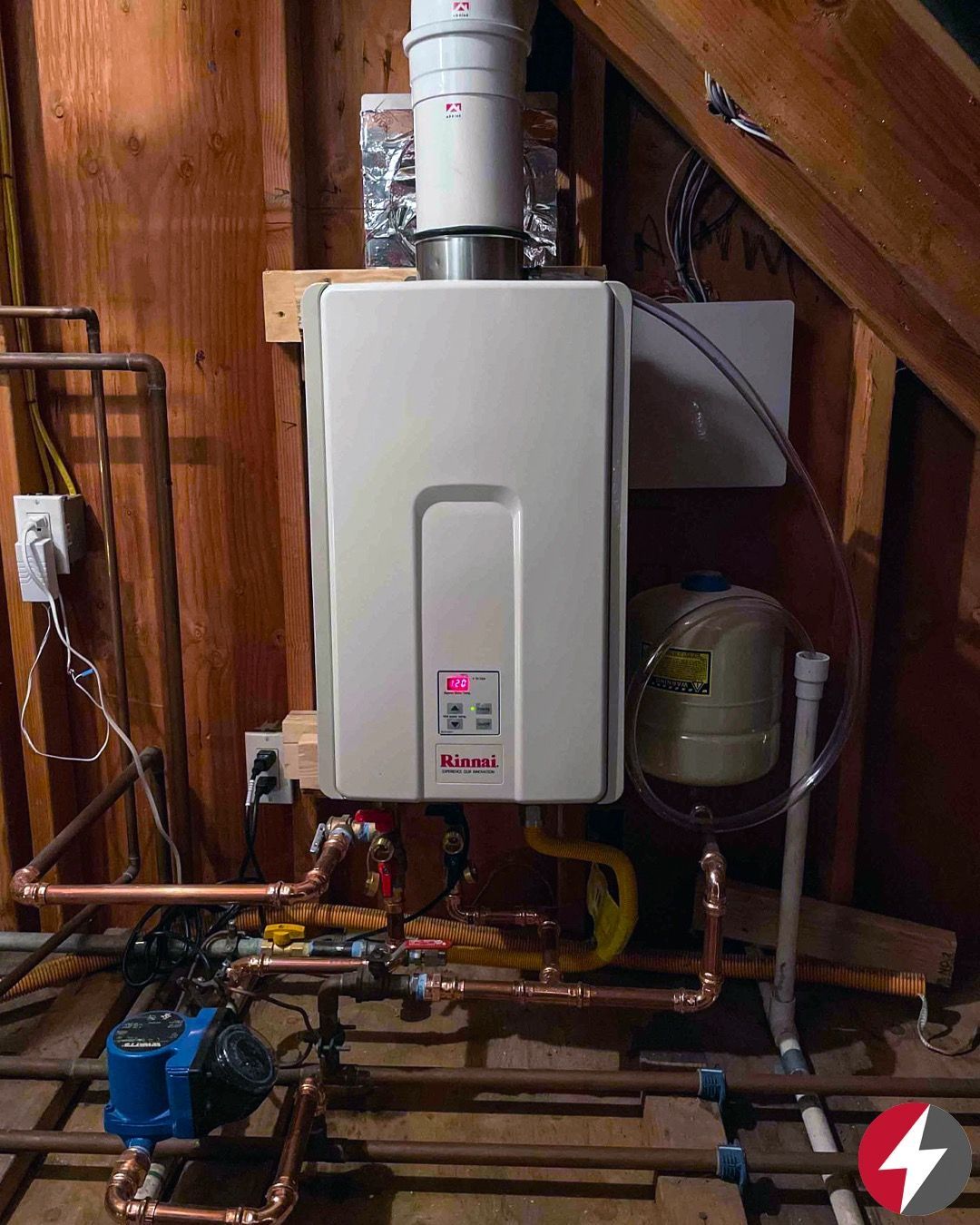 Man in gloves repairing a white boiler inside a metal cabinet; indoor setting.