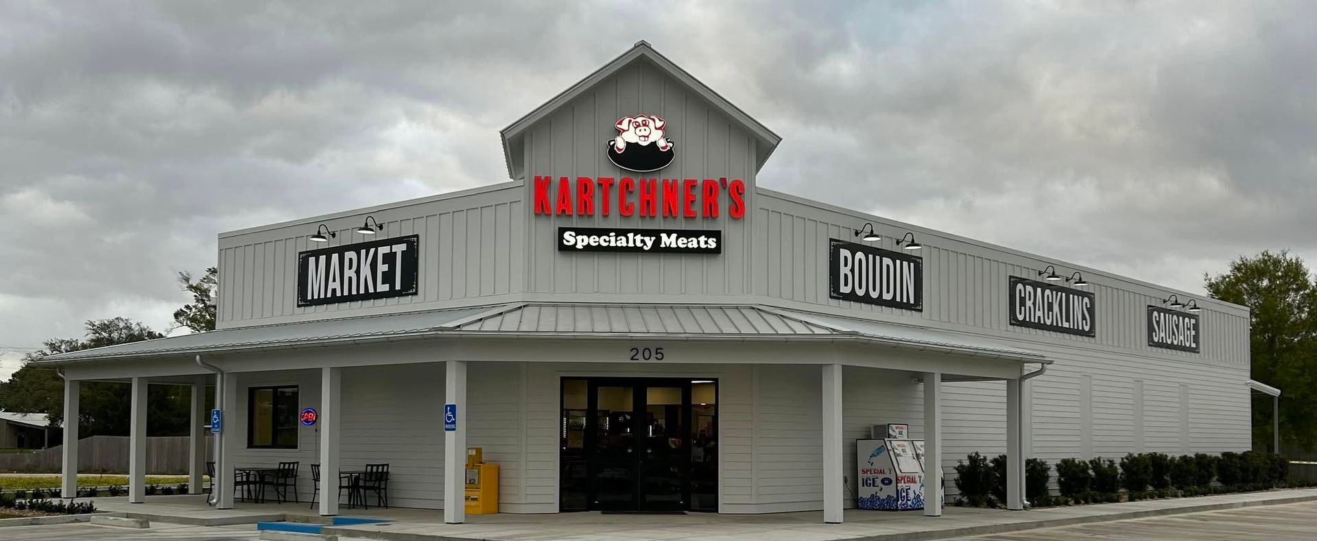 Exterior of Hart's Grocery store. The white building has a gable roof and a red sign with 