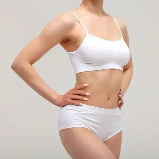 A woman in white underwear is standing with her hands on her hips