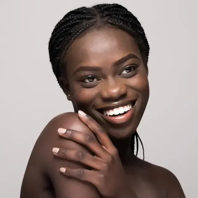 A woman is smiling with her hand on her shoulder