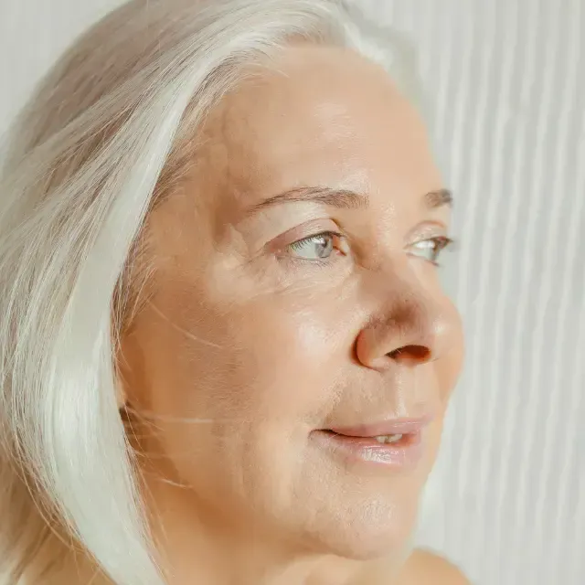 A close up of a woman 's face with white hair.