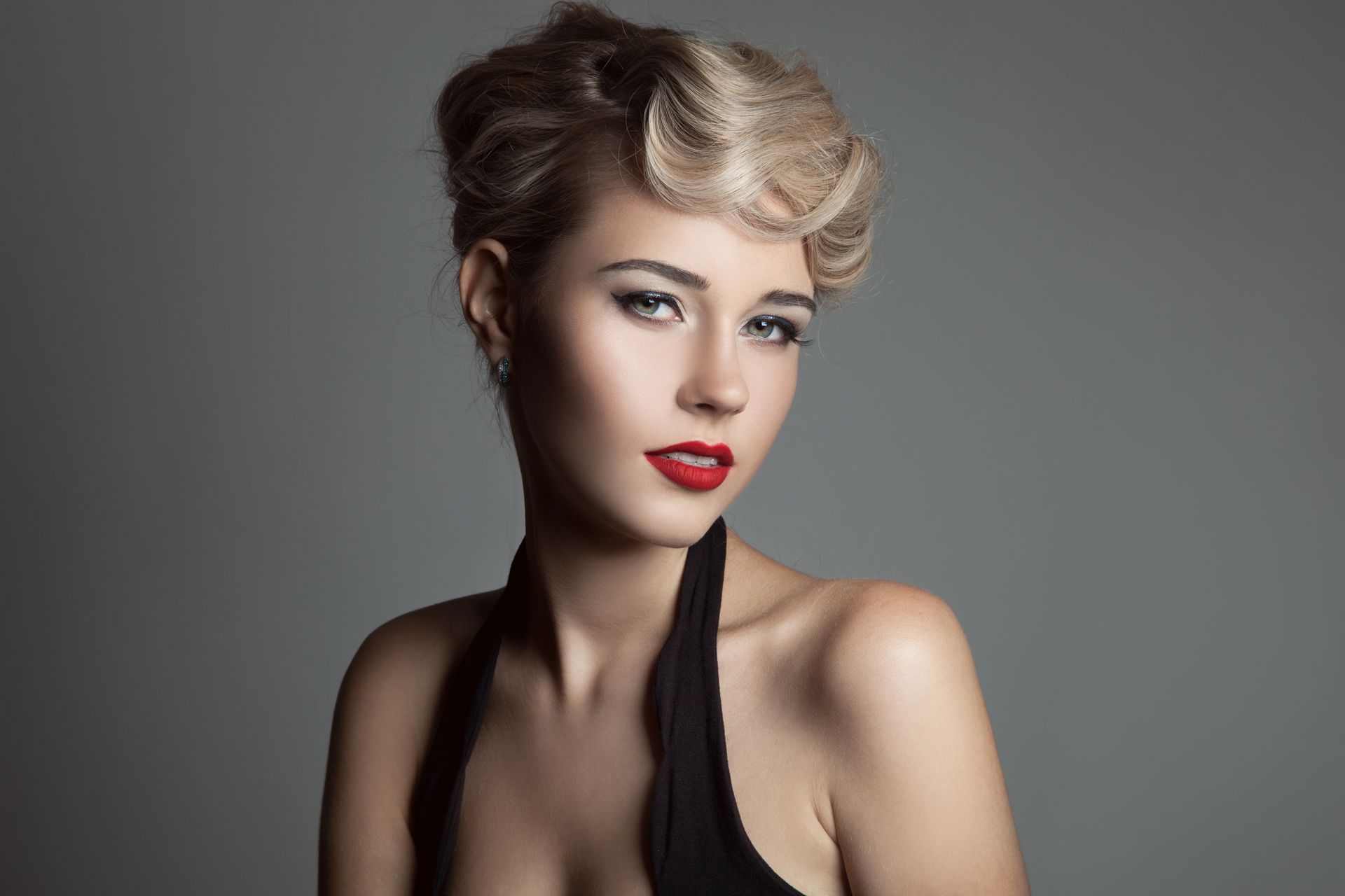 The woman is wearing a black dress and red lipstick.