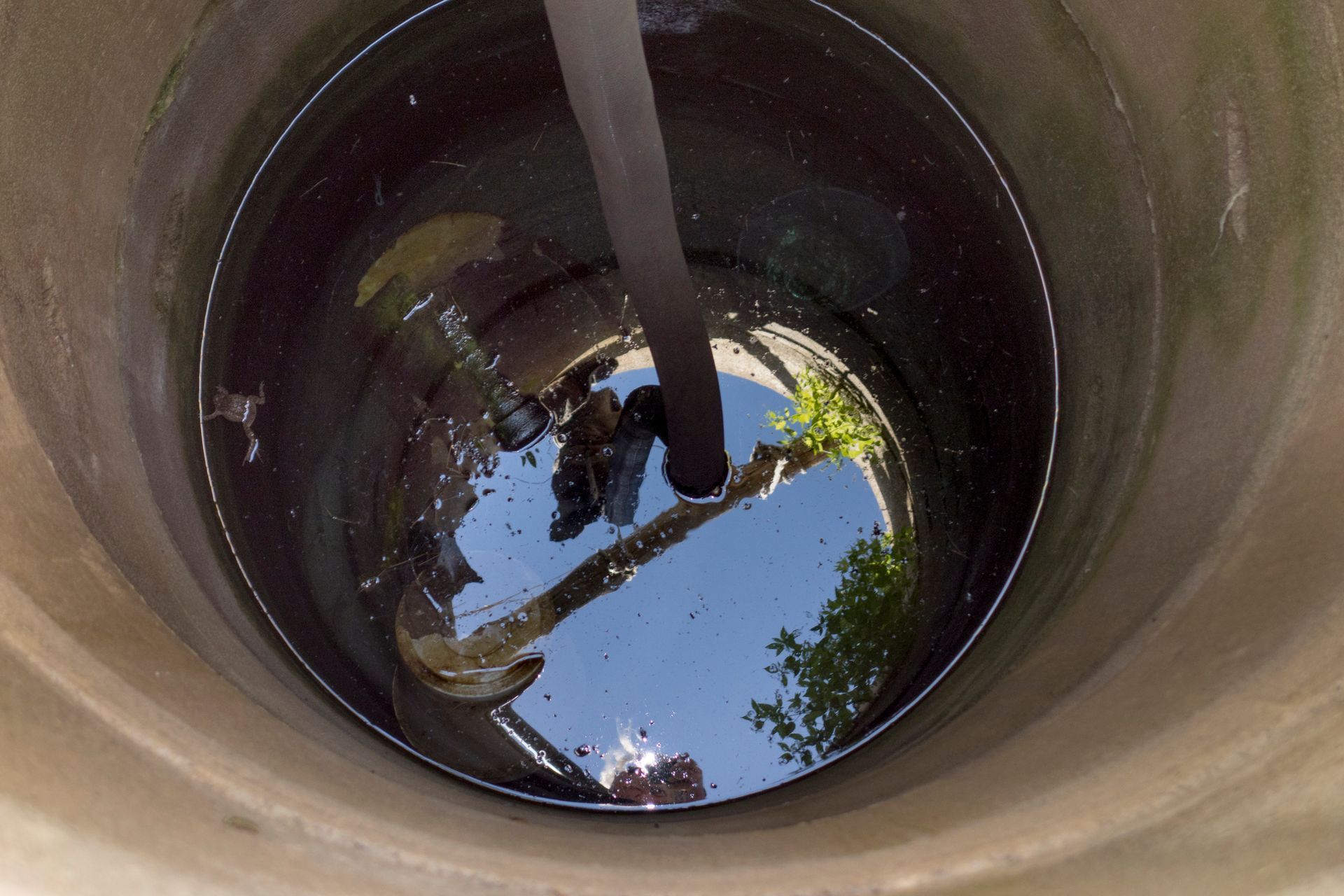 A person is standing in a well filled with water.