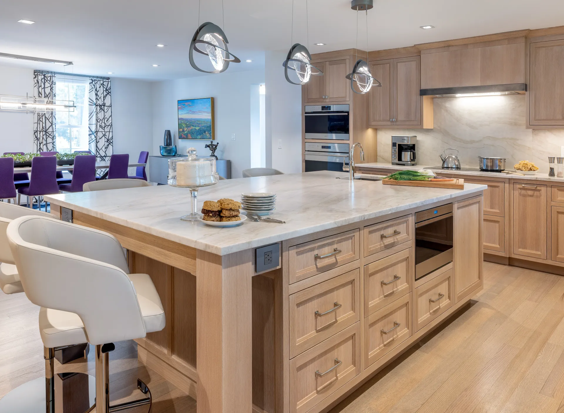 Bright modern kitchen with large island, wood cabinets, and pendant lights