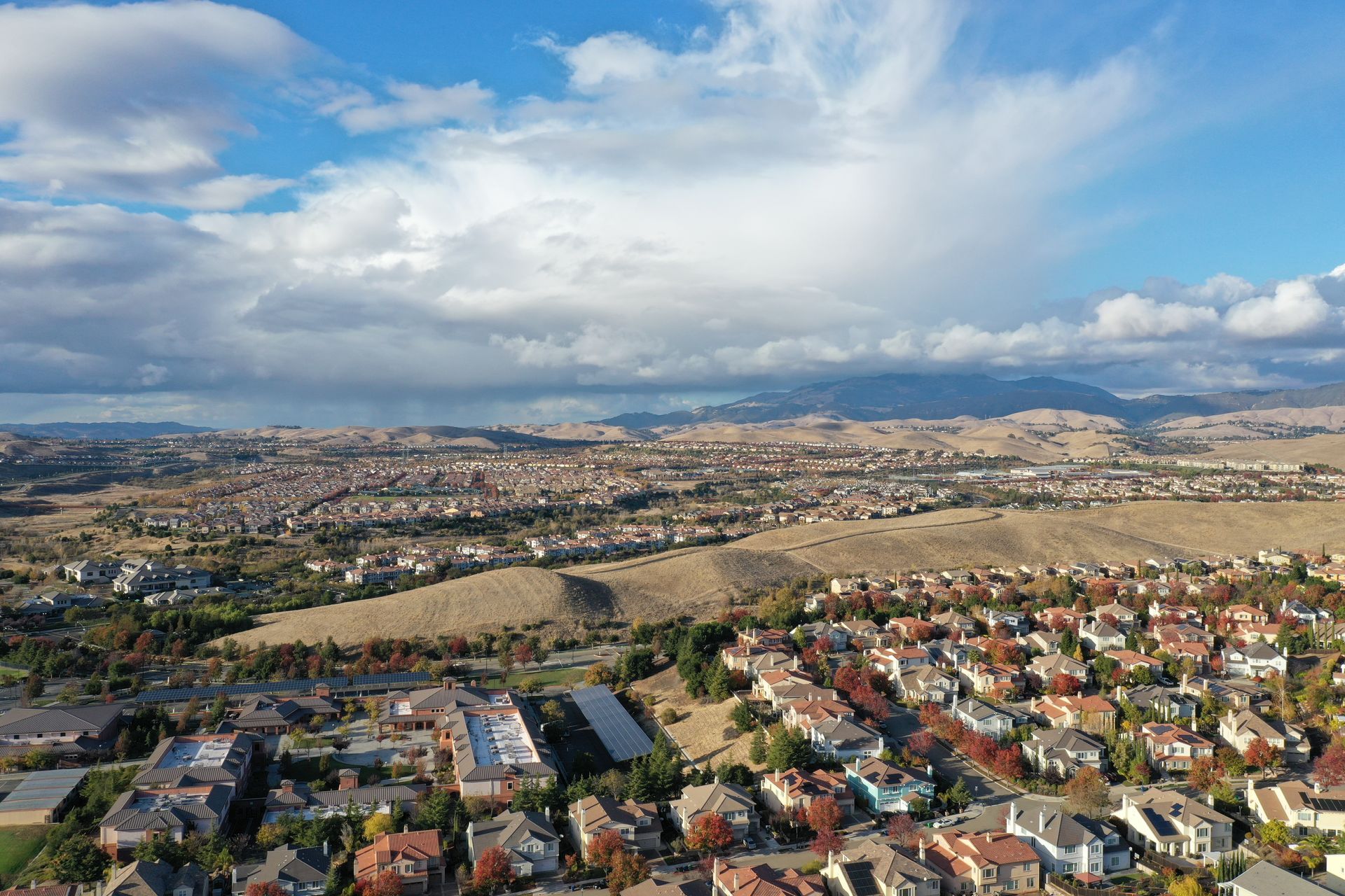 An aerial view of a residential area with mountains in the background.
