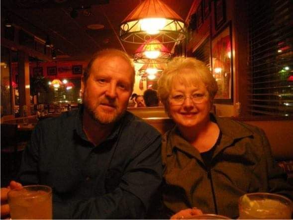 A man and a woman are posing for a picture in a restaurant