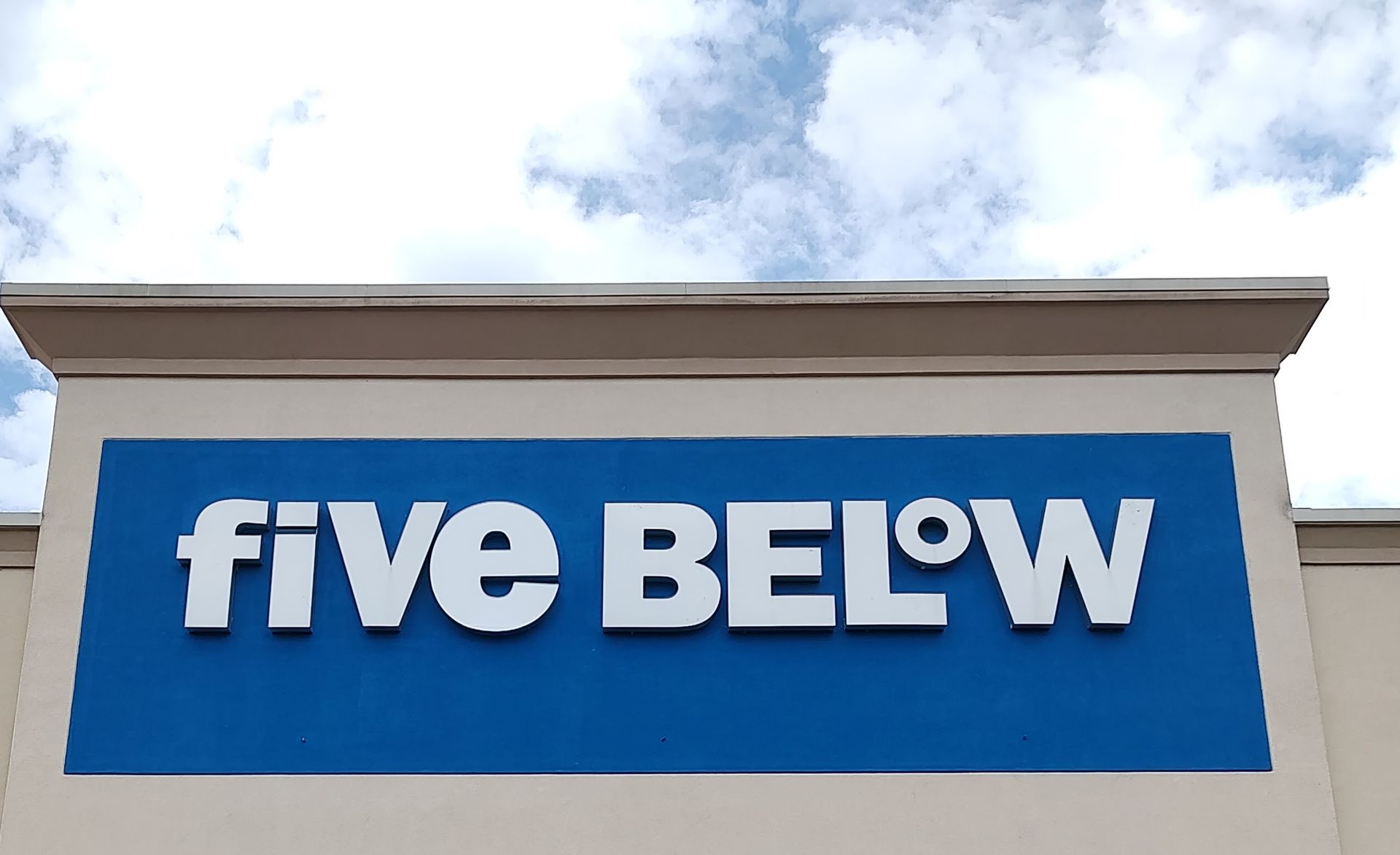 A blue and white sign that says five below