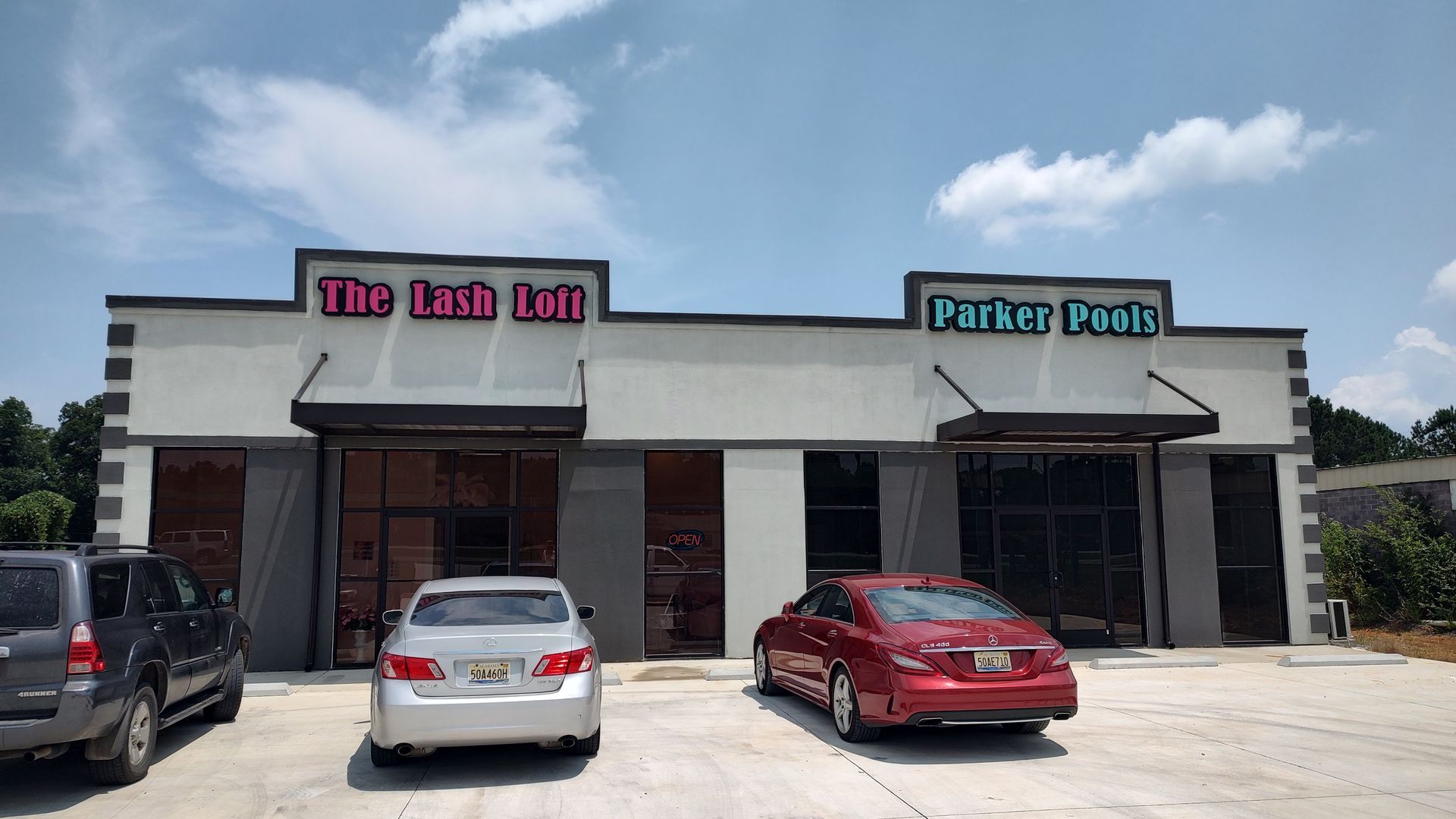 A couple of cars are parked in front of a building.